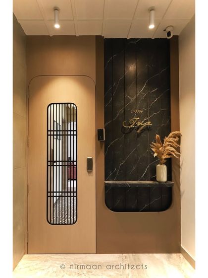 The entrance to our 'Atmosphere' project features a custom door and a black marble nameplate niche. The design is sleek, modern, and sets a tone of understated luxury.