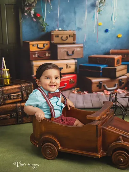Let the adventures begin. This little explorer is ready for his journey in a vintage-themed studio setup. I provide a wide range of props like this wooden car and classic suitcases to create playful, imaginative portraits for your child.