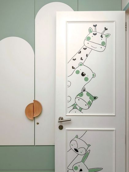 A detailed shot of the hand-drawn animal characters on the kids' room door, a small detail that brings immense joy.