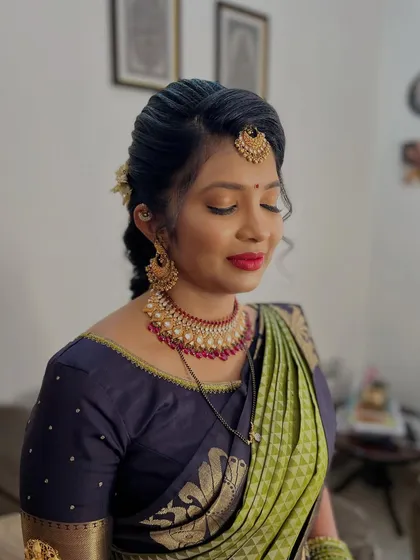 This look is all about traditional elegance. I created a soft makeup look with a classic red lip and paired it with a neat, braided hairstyle, perfect for any South Indian wedding function.