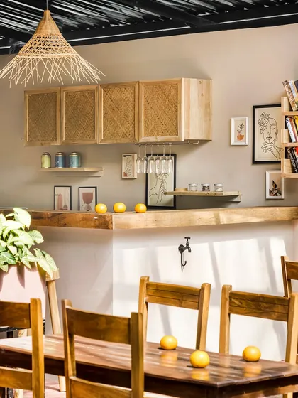 The communal bar and dining area at Unallome is crafted from natural wood and rattan. The space is designed to be simple and functional, allowing the beauty of the materials and the surrounding nature to take center stage.