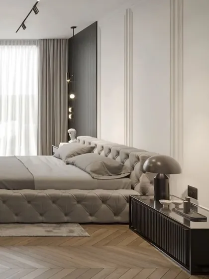 Another view of the elegant bedroom, highlighting the natural light from the large window and the comfortable reading chair.