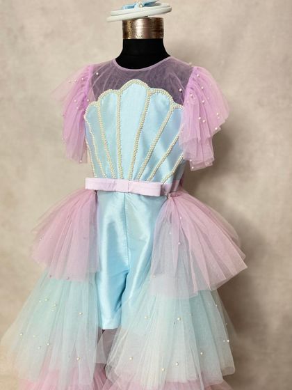 A closer look at our mermaid playsuit with its detachable trail. The seashell bodice is detailed with delicate pearls, and the layered tulle mimics the colors of the ocean.