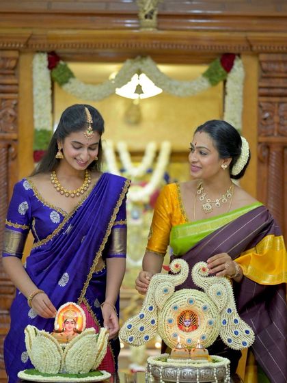 A mother and daughter share a special moment during a festival, their traditional sarees connecting them to their heritage.