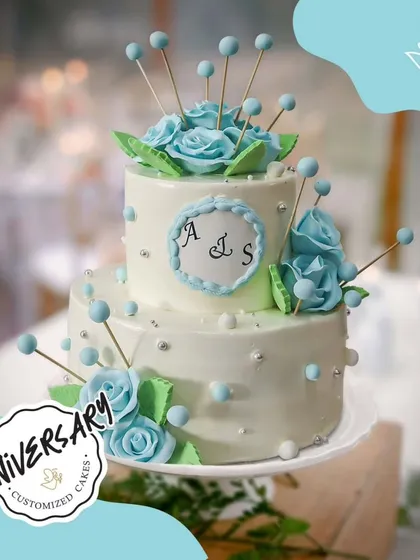 For Ashna and Samay's anniversary in DLF Phase 1, I designed this elegant two-tier cake. The delicate blue roses and personalized monogram make it a beautiful symbol of their special bond.