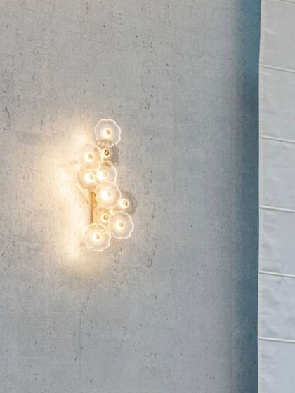 A collection of detail shots from "The White House" project, focusing on material interplay: artistic light fixtures on concrete walls, elegant mirrors, and the transition between wood and patterned flooring.