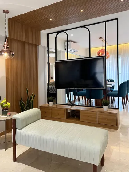 This innovative two-way TV unit acts as a partition between the living and dining areas. The screen can be rotated, serving both spaces with one elegant solution.