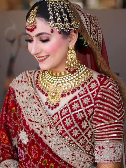A candid, smiling profile shot that shows off the complete look, from the hairstyle and jewelry to the beautiful drape of her dupatta.