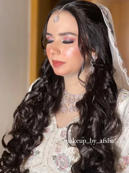 This bride's white outfit is so angelic. I gave her soft, romantic curls and a pink-toned makeup look to match.