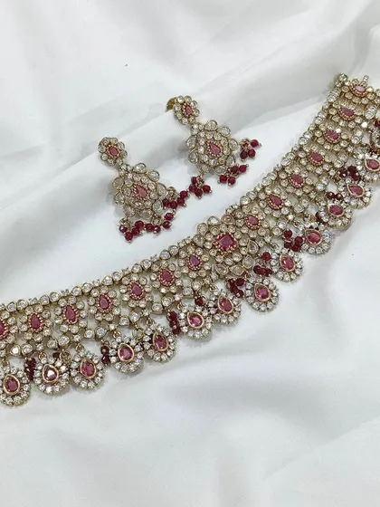A classic combination of ruby-red stones and sparkling white stones. This choker set is perfect for adding a pop of color and a touch of tradition to a modern outfit.
