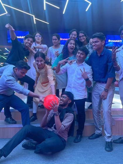 Some candid shots of a group of friends having a great time, with one playfully holding a bowling ball while another lies on the floor.