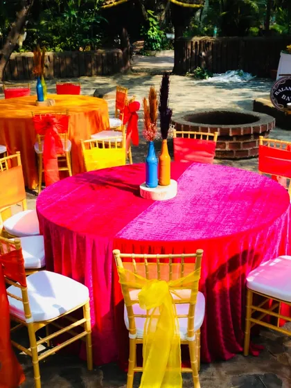 Another example of our colorful table settings, combining a bright pink tablecloth with yellow and orange chair decor for a festive look.