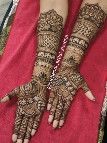 A rich and dense bridal design that incorporates peacocks on the arms and a mix of elephants, lotuses, and florals on the hands. The use of dark and light henna creates wonderful depth.