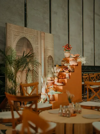 A decor corner at the Turkish Haldi, with a stepped display for props and a backdrop featuring a printed image of a Turkish facade.