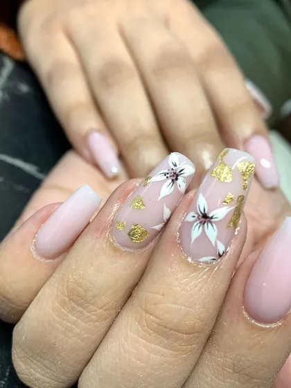 A beautiful and elegant design for long nails. This set features a soft, milky base with hand-painted white flowers and delicate gold foil accents.