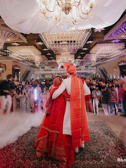 A shot from the back of the couple as they face their guests in a grand hall, capturing the scale of the celebration and their unity.