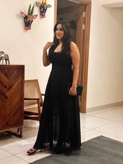 A full-length view of Sanjana's custom black gown, showcasing its flowing chiffon skirt and fitted velvet bodice.