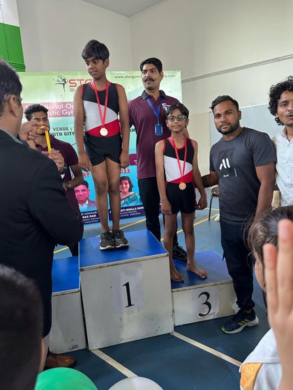 Here I am with my student on the winner's podium at the 1st Star Invitational Inter-School Artistic Gymnastics Championship. Seeing them achieve their goals is my biggest motivation.