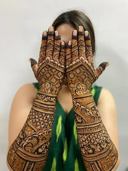 A full back-hand design with intricate grids and paisleys, perfect for a bride who wants her hands adorned from every angle.