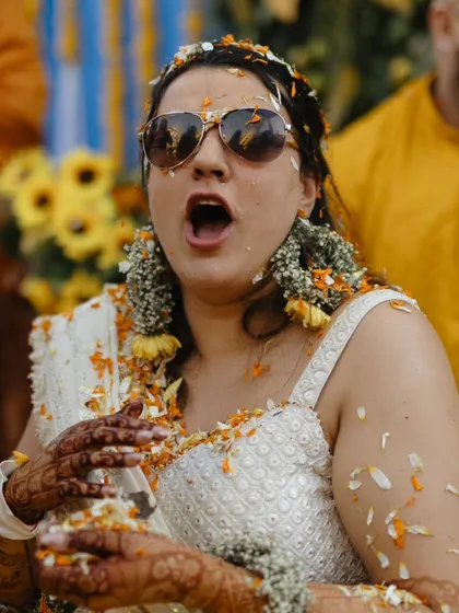 A candid shot of a guest reacting with surprise and laughter during a lively Haldi celebration, showcasing the fun atmosphere.