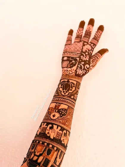 The other arm of the same design, showing the intricate patterns and storytelling elements that continue around the arm.