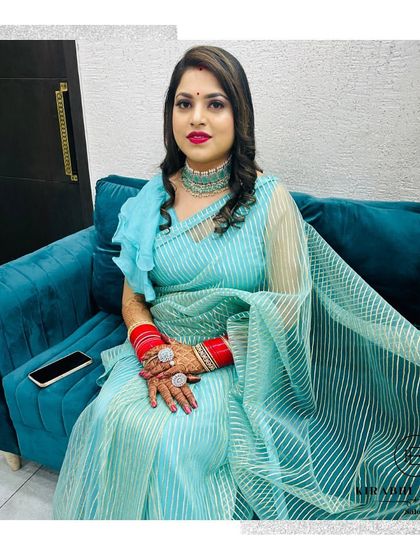 A full view of this stunning party look. The client looks elegant and poised in her light blue saree, with her hair and makeup done by us.