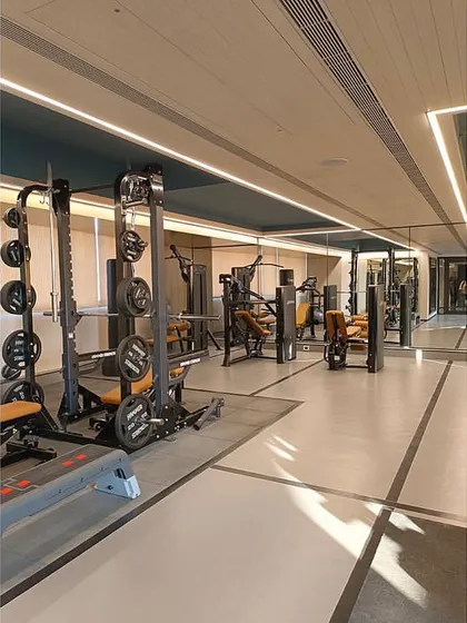 The gym includes a variety of strength and cardio equipment, organized to maximize space and functionality for residents.
