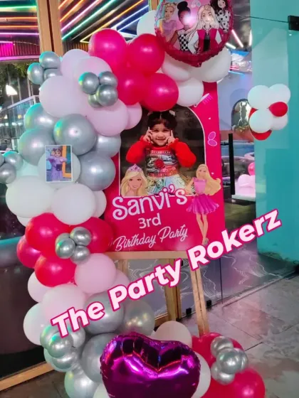 A welcome stand for a Barbie-themed 3rd birthday party. We created a balloon garland in pink, white, and silver around a personalized welcome board with the birthday girl's photo.