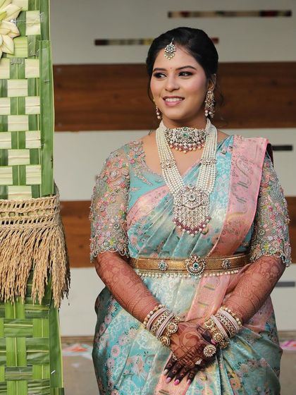 A smiling bride in her pastel blue saree, looking absolutely radiant and happy.