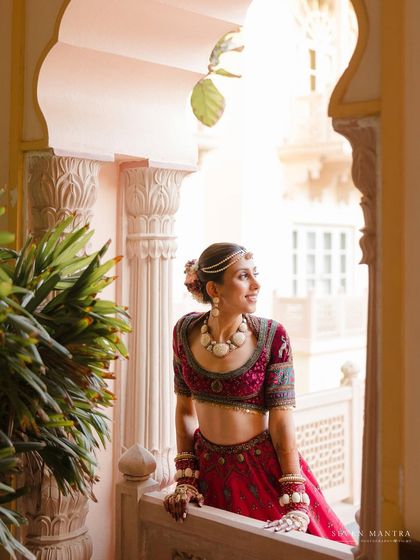 A bride looking out from a palace balcony. This shot captures a moment of quiet reflection amidst the grandeur of her surroundings.