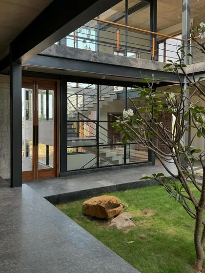 An internal courtyard at the 6AM House, with a young tree at its center. This design element brings nature directly into the heart of the home, softening the raw concrete and steel structure.