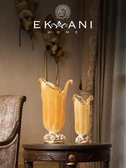 This pair of Murano glass vases, with their unique organic shapes and porcelain rose bases, showcases the quiet drama of Venetian heritage. No two pieces are ever the same, each carrying the delicate fingerprint of its maker.