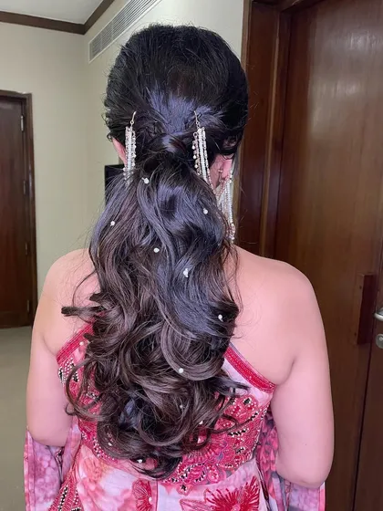 The full back view of the messy ponytail with pearls, showing off its texture and volume.