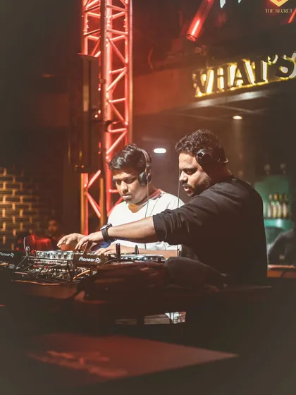 In deep concentration with another DJ at the console. This image shows the collaborative and technical side of a live set, with both of us working together on the Pioneer decks.
