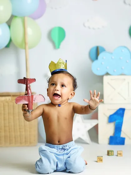 Capturing the excitement of turning one. This little boy, wearing a crown and holding a toy plane, is full of energy in this travel-themed first birthday shoot.