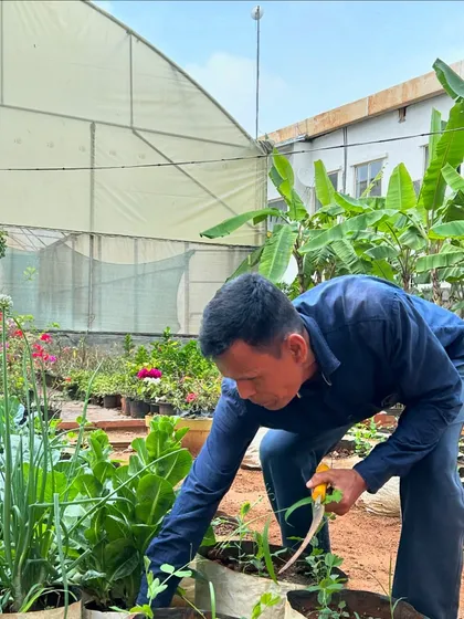 A farmer works in our open-field garden, tending to the plants with care. We are grateful for the hard work of every person who helps grow our food.