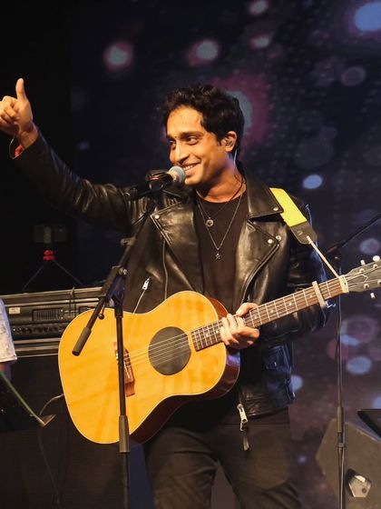 Nikhil D'Souza giving a thumbs-up to the audience, showcasing his great rapport with students.