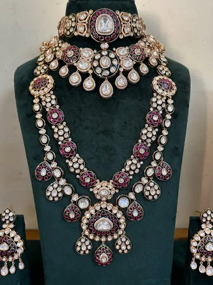 A stunning bridal jewellery set in a rich maroon and white Kundan design. This rental piece includes a choker, a mid-length necklace, a long Rani Haar, and matching earrings for a complete, royal look.