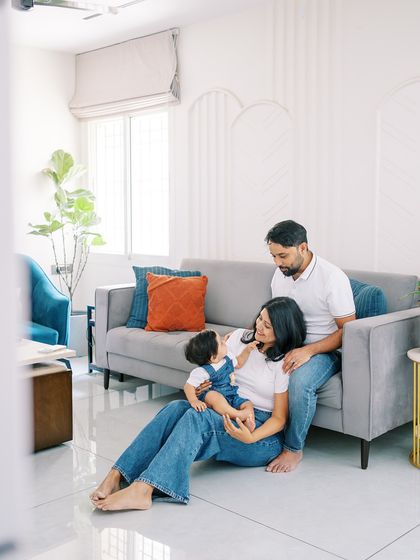 A family in matching denim, sitting on the floor of their home. A simple and classic look for a relaxed family portrait.