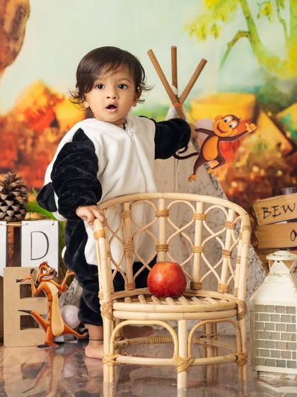 Standing tall and ready to explore. This 'Wild One' is curious about all the details in his jungle-themed first birthday setup.