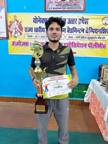 Akash Singh holding his runner-up trophy from the Uttar Pradesh Badminton Championship. This individual achievement is a result of his relentless effort and training.