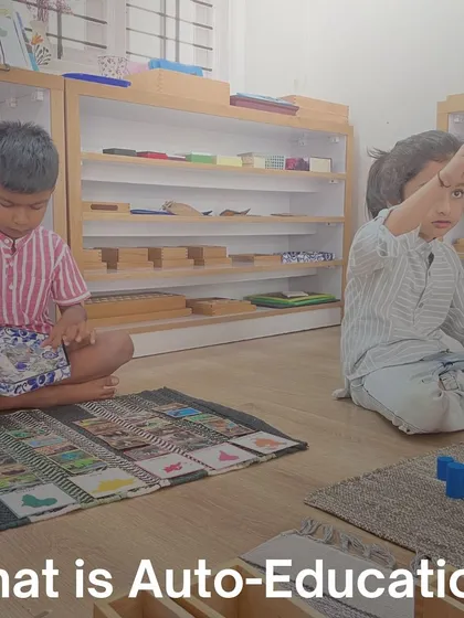 Two children work independently on different activities in the same space. This illustrates auto-education, or self-directed learning, where the prepared environment allows each child to follow their own interests.