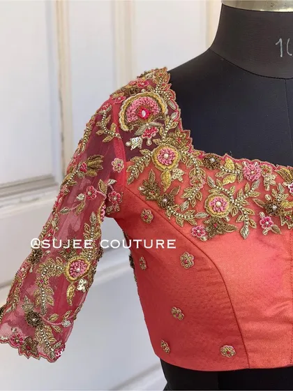 The front of the sheer wine-colored blouse. The sweetheart neckline and sheer sleeves create a modern and romantic look, perfect for an evening reception.