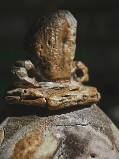 A detailed shot of the top of the wood-fired sculpture. The rough, organic finish is a hallmark of this firing technique, where imperfections are not flaws but proof of the journey.