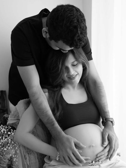 A loving kiss on the head. This intimate black and white image is a beautiful testament to the couple's bond and the journey they are on together.