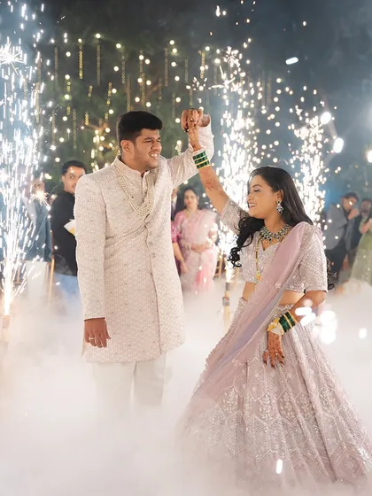 A magical moment as the couple dances, surrounded by sparklers. The bride's lehenga and open hairstyle are perfect for a night of celebration.