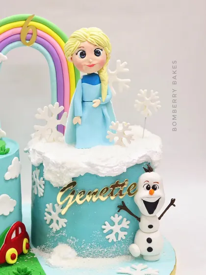 A close-up of the "Frozen" side of the twins' cake, with an Elsa figurine and a happy Olaf.