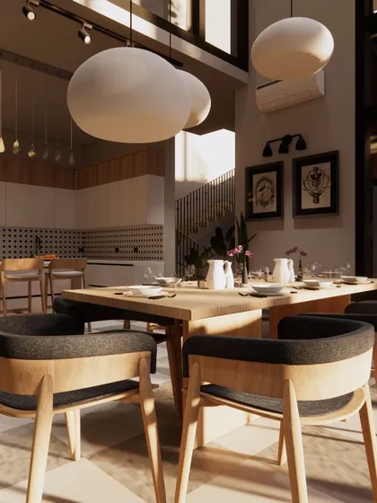 Sunlight streams into this dining area, highlighting the natural wood table and chairs. The oversized, cloud-like pendant lights add a soft, sculptural element to the room.