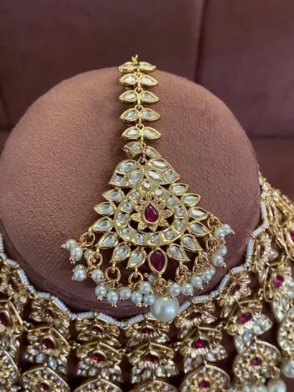 A close-up of the maang tikka from the modern ruby choker set. The design is delicate yet makes a statement.