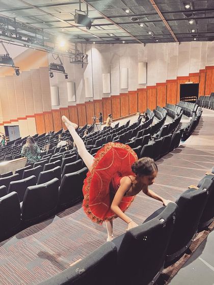 A ballerina takes a moment in the empty auditorium during rehearsals. The calm before the storm.